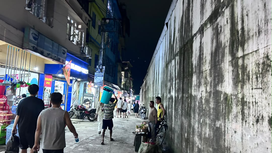 Walking along the market lane beside a boundary wall